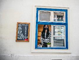 woman, face mask, shopping through an open window, street, Prague, epidemic, coronavirus