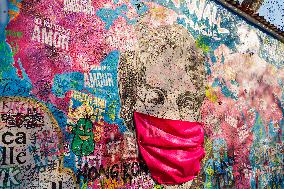 John Lennon portrait with a protection face mask on the Lennon Wall on Kampa Island in Prague