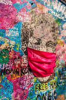 John Lennon portrait with a protection face mask on the Lennon Wall on Kampa Island in Prague