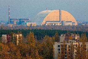 Chernobyl zone, restricted territory, aerial view on deserted town of Pripyat and secure dome over the damaged Chernobyl nuclear reactor number 4