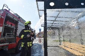 firefighter disinfects a bus stop against coronavirus