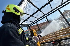 firefighter disinfects a bus stop against coronavirus