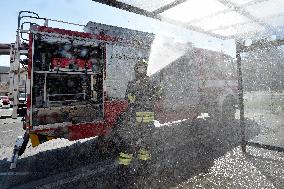 firefighter disinfects a bus stop against coronavirus