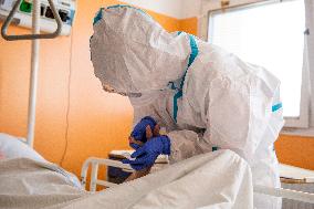 a medic in a protective suit tests a covid-19 patient