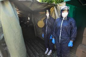 medics prepare to take samples for a covid-19 test from volunteers