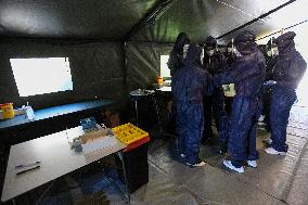 medics prepare to take samples for a covid-19 test from volunteers