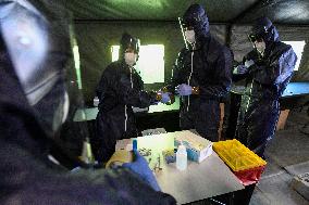 medics prepare to take samples for a covid-19 test from volunteers