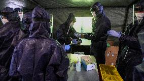 medics prepare to take samples for a covid-19 test from volunteers