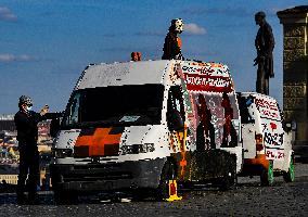 Two vans with edited photos of Milos Zeman and Vratislav Mynar, pointing out that Mynar organized a slaughterhouse a week ago, park on the Hradcany Square