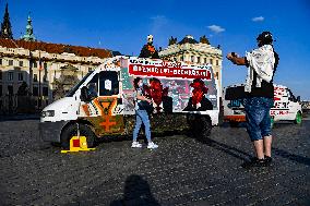 Two vans with edited photos of Milos Zeman and Vratislav Mynar, pointing out that Mynar organized a slaughterhouse a week ago, park on the Hradcany Square