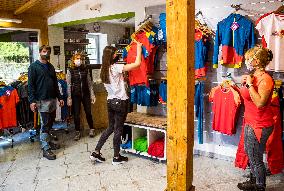 Shop Hudysport with outdoor and sports equipment, sales assistant, customer, face mask