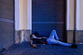 a homeless man in a protection face mask sleeps in Krizovnicka Street in Prague