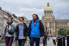 People without face masks walk on Wenceslas Square in Prague