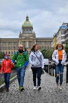 People without face masks walk on Wenceslas Square in Prague