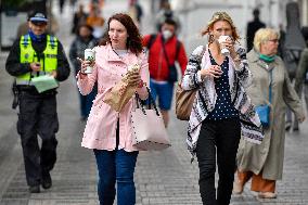 People without face masks walk on Wenceslas Square in Prague