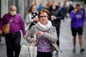 People without face masks walk on Wenceslas Square in Prague