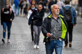 People without face masks walk on Wenceslas Square in Prague