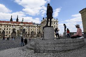 people walk on Hradcany Square in Prague