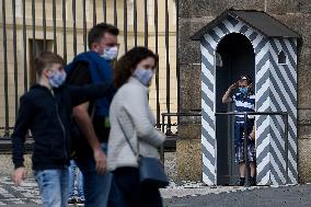 people walk on Hradcany Square in Prague