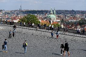 people walk on Hradcany Square in Prague