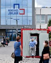 a medic in a protective suit takes a sample for a covid-19 test in the Jihlava hospital testing point