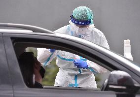 a medic in a protective suit takes a sample for a covid-19 test in the Jihlava hospital testing point