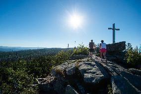 Bohemian Forest, Trojmezna Mountain (Three-border Mountain), tourists, sun, crucifix, rock