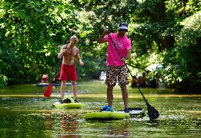 Men ride a stand-up paddleboard in Mlynsky potok