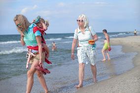 Two ladies with the child on walking on the beach in the Piaski village at the Baltic sea coast