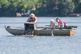 volunteers move clams from shallows of the Bolevecky pond in Pilsen