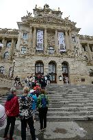 People stand a queue in front of the historical building of National Museum