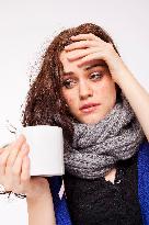 A beautiful young woman, lady, girl, cold, runny nose, headache, cup of tea, scarf, hot drink