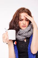 A beautiful young woman, lady, girl, cold, runny nose, headache, cup of tea, scarf, hot drink