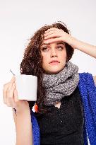 A beautiful young woman, lady, girl, cold, runny nose, headache, cup of tea, scarf, hot drink