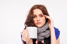 A beautiful young woman, lady, girl, cold, runny nose, headache, cup of tea, scarf, hot drink