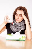 A beautiful young woman, lady, girl, cold, runny nose, headache, tissues, paper hankies, cup of tea, scarf, handkerchiefs, handkerchief