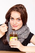 A beautiful young woman, lady, girl, cold, runny nose, headache, tea, honey, spoon, scarf.