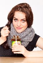 A beautiful young woman, lady, girl, cold, runny nose, headache, tea, honey, spoon, scarf.