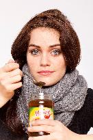 A beautiful young woman, lady, girl, cold, runny nose, headache, tea, honey, spoon, scarf.