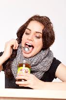 A beautiful young woman, lady, girl, cold, runny nose, headache, tea, honey, spoon, scarf.