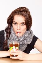 A beautiful young woman, lady, girl, cold, runny nose, headache, tea, honey, spoon, scarf.