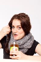 A beautiful young woman, lady, girl, cold, runny nose, headache, tea, honey, spoon, scarf.