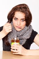 A beautiful young woman, lady, girl, cold, runny nose, headache, tea, honey, spoon, scarf.