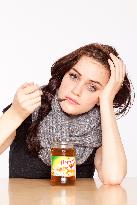 A beautiful young woman, lady, girl, cold, runny nose, headache, tea, honey, spoon, scarf.