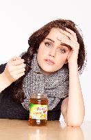 A beautiful young woman, lady, girl, cold, runny nose, headache, tea, honey, spoon, scarf.