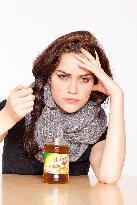 A beautiful young woman, lady, girl, cold, runny nose, headache, tea, honey, spoon, scarf.