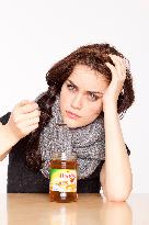 A beautiful young woman, lady, girl, cold, runny nose, headache, tea, honey, spoon, scarf.