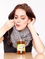 A beautiful young woman, lady, girl, cold, runny nose, headache, tea, honey, spoon, scarf.