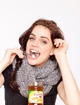 A beautiful young woman, lady, girl, cold, runny nose, headache, tea, honey, spoon, scarf.