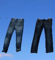 Jeans (blue)  hanging on a rope, clothes pins pegs